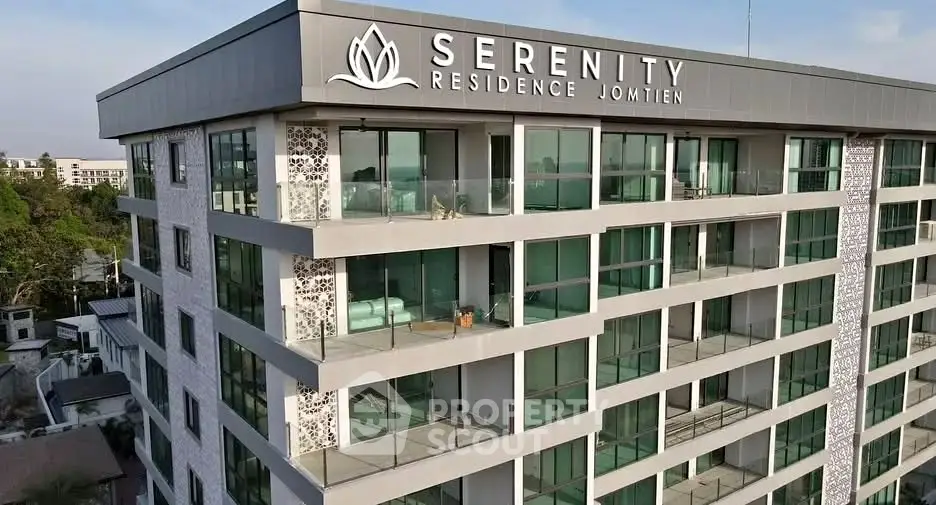Modern Serenity Residence building with glass balconies and lush surroundings in Jomtien.