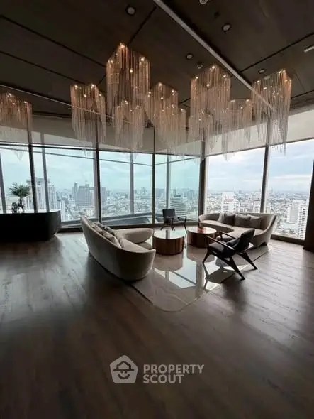 Luxurious high-rise living room with panoramic city views and elegant chandeliers.