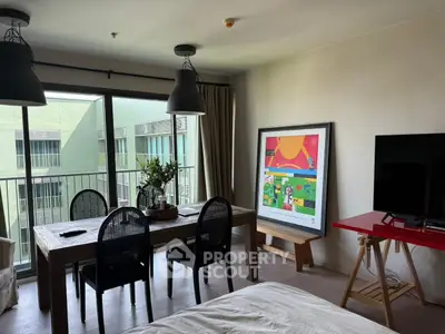 Modern living room with balcony, stylish decor, and natural light