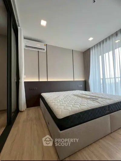 Modern bedroom with large windows and stylish decor in a luxury apartment.