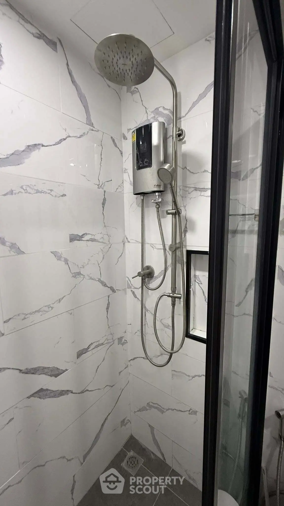 Modern bathroom with sleek shower fixtures and marble-style tiles