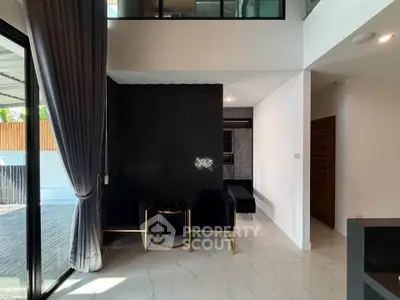 Modern living room with elegant black and white decor, featuring large windows and stylish furniture.