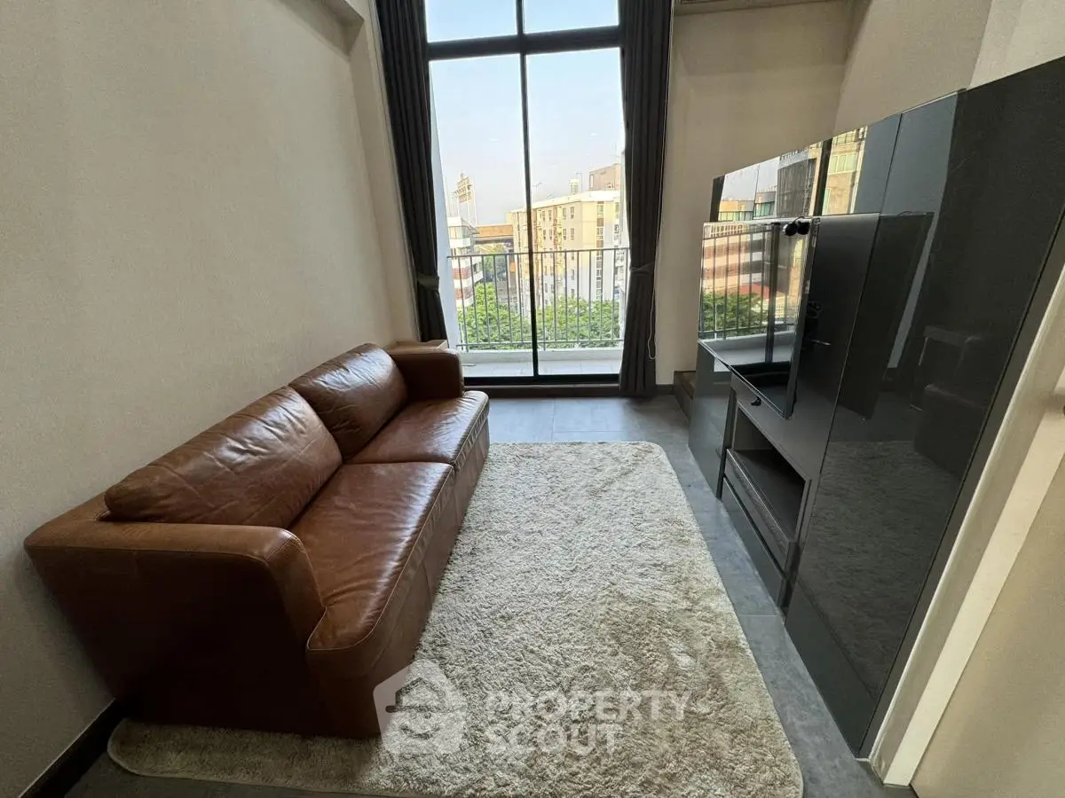 Modern living room with leather sofa and large window overlooking cityscape