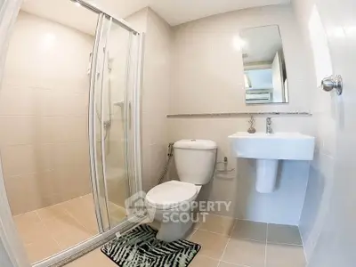 Modern bathroom with glass shower and sleek fixtures in a contemporary apartment.