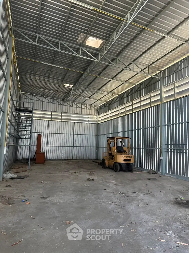 Spacious industrial warehouse with high ceilings and metal shelving