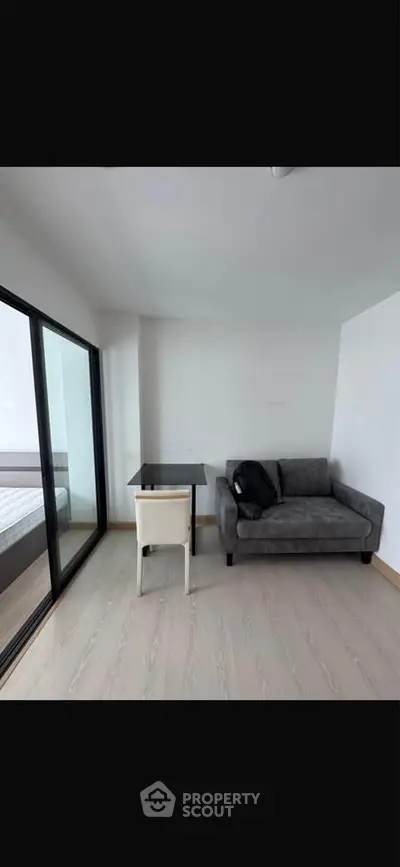 Modern living room with sleek sofa and glass table near balcony
