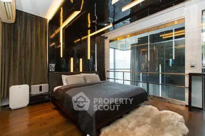 Luxurious modern bedroom with sleek black wall and glass partition, featuring elegant lighting and plush rug.