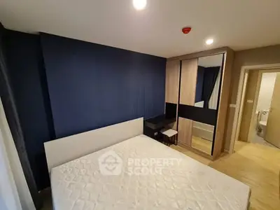 Modern bedroom with blue accent wall and mirrored wardrobe