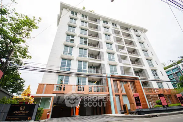 Modern condominium building with sleek design and spacious balconies in urban setting.