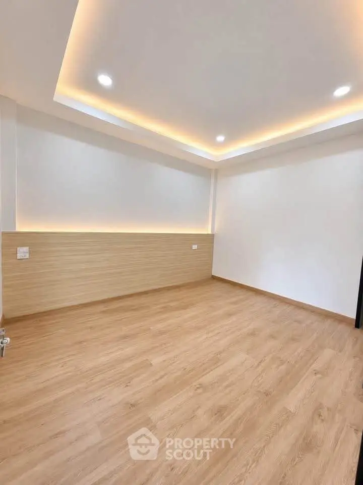 Spacious modern room with elegant lighting and wooden flooring
