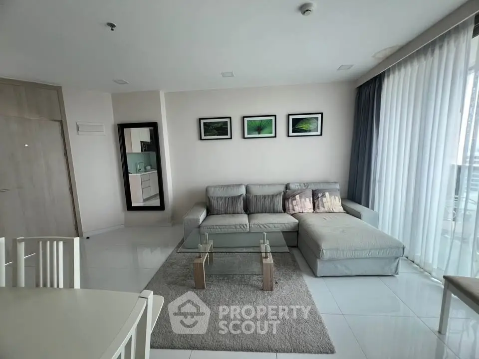 Modern living room with stylish decor and large windows offering natural light.