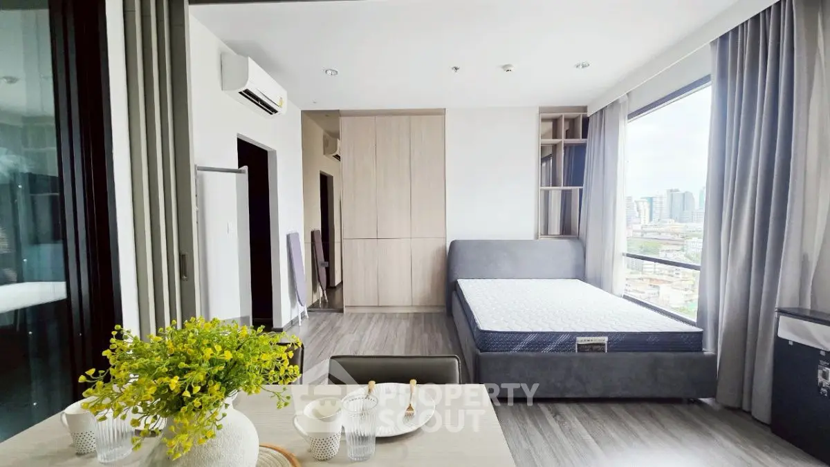 Modern studio apartment with large windows and city view
