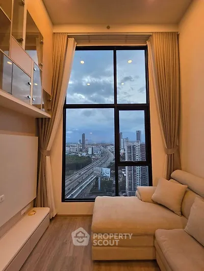 Luxurious high-rise living room with stunning city view through large windows, featuring elegant furnishings.