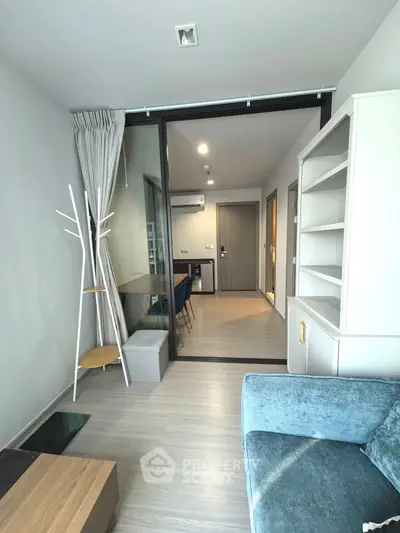 Modern living room with sleek furniture and glass partition in a stylish apartment.