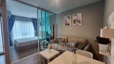 Modern apartment interior with cozy living room and stylish bedroom separated by glass partition.