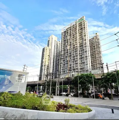 Modern high-rise building with lush greenery and clear blue sky