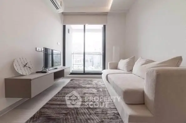 Modern living room with sleek furniture and large window offering city view.