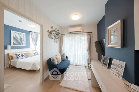 Modern living room with stylish decor and natural light, adjacent to a cozy bedroom.