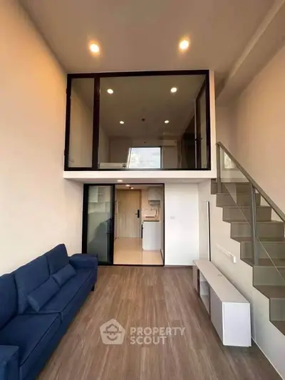 Modern loft apartment with stylish mezzanine and open living area, featuring sleek staircase and contemporary design.