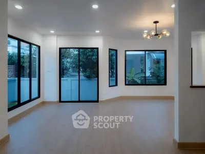 Spacious modern living room with large windows and elegant lighting