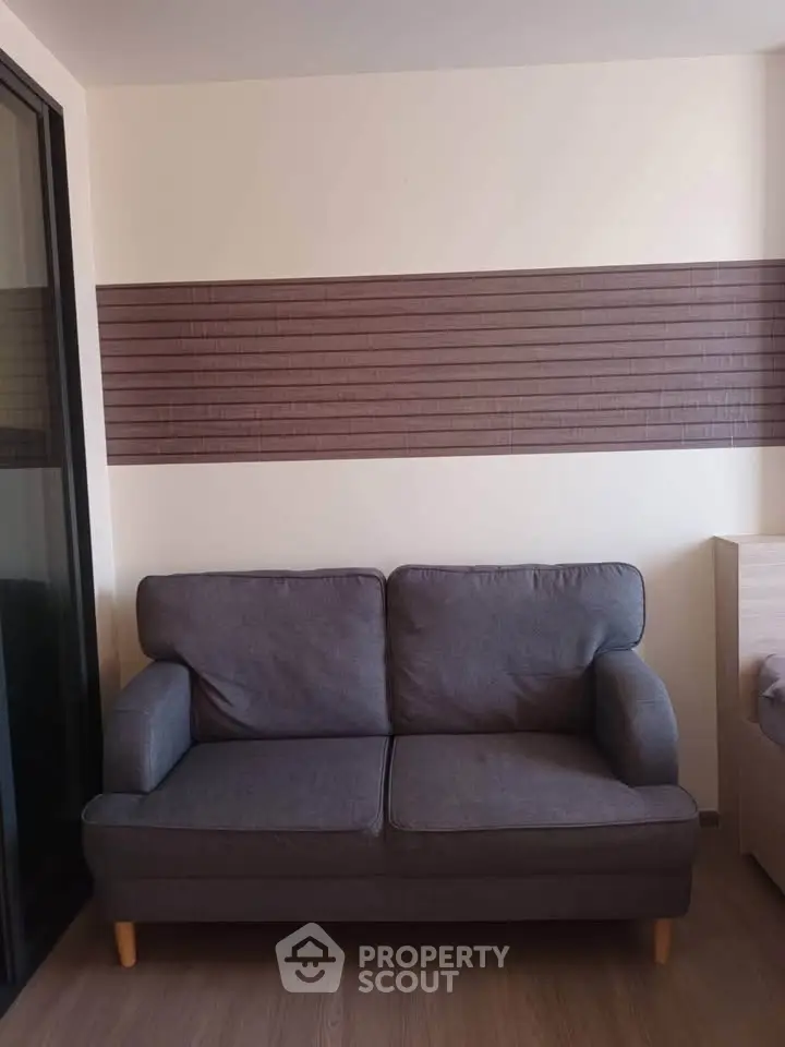 Modern living room with stylish gray sofa and wooden flooring, perfect for cozy relaxation.