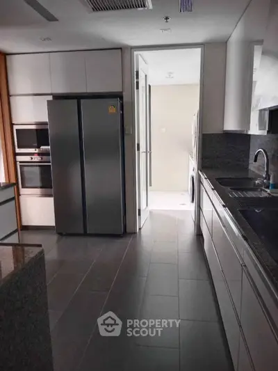 Modern kitchen with sleek appliances and granite countertops in a contemporary home.