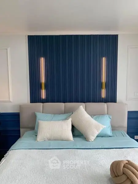 Luxurious bedroom with modern blue accent wall and elegant lighting