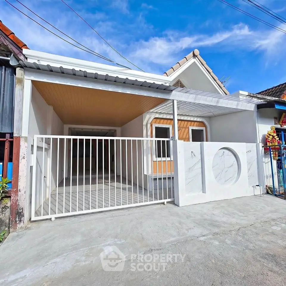 Charming single-story home with modern facade and gated driveway under a clear blue sky.