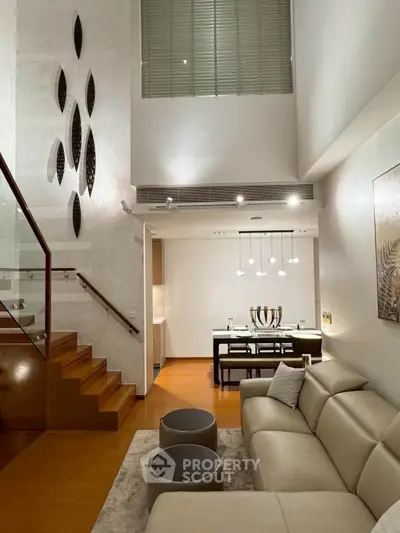 Luxurious modern living room with high ceiling and elegant dining area