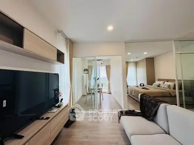 Modern open-plan living room with stylish decor and spacious bedroom view.