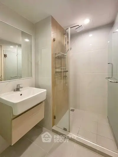 Modern bathroom with sleek shower and elegant vanity in contemporary design.