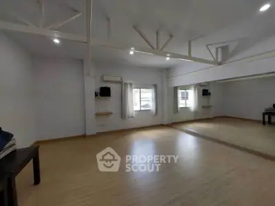 Spacious room with large mirror and wooden flooring, ideal for dance or yoga studio.