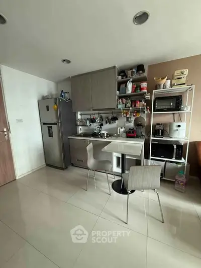 Modern compact kitchen with sleek appliances and open shelving in a cozy apartment setting.