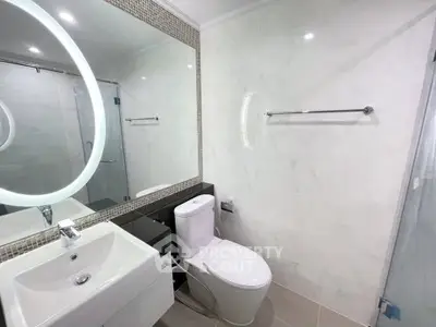 Modern bathroom with elegant fixtures and large mirror in a stylish real estate property.