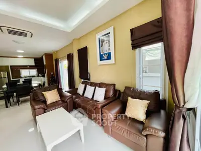 Spacious living room with leather sofas and modern decor in a stylish home.