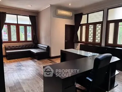 Spacious office with modern furniture and large windows for natural light.