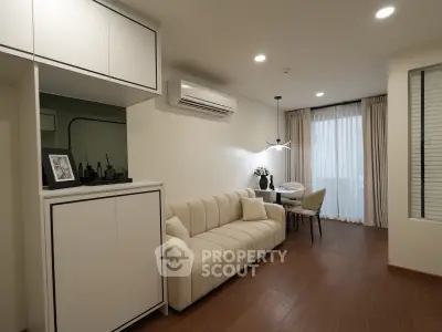 Modern living room with elegant decor and natural light, featuring a cozy sofa and stylish dining area.