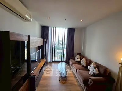 Modern living room with city view, featuring stylish furniture and large windows.