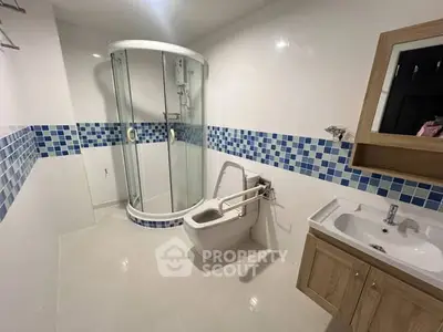 Modern bathroom with glass shower and blue mosaic tiles