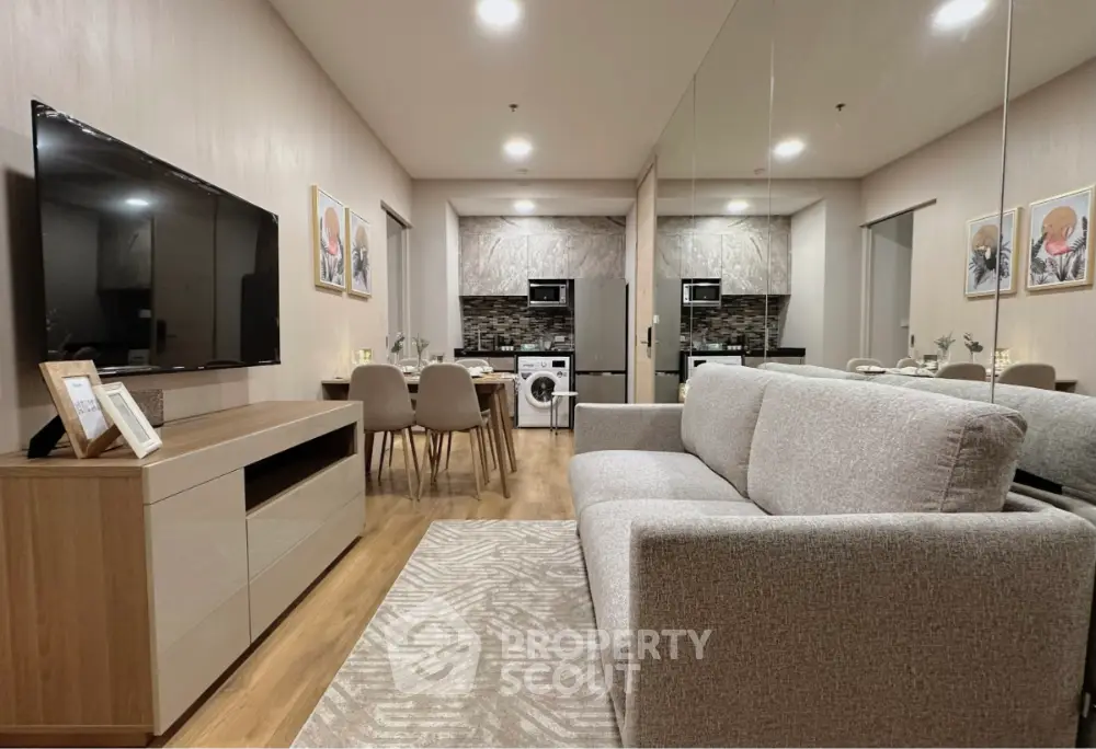Modern living room with stylish decor and open kitchen layout featuring a washing machine and dining area.