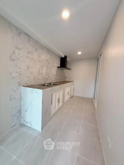 Modern kitchen with sleek marble backsplash and ample counter space