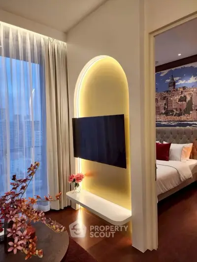 Luxurious modern living room with stylish TV setup and glimpse into elegant bedroom.