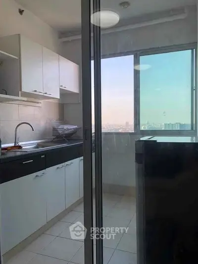 Modern kitchen with sleek cabinets and city view from window