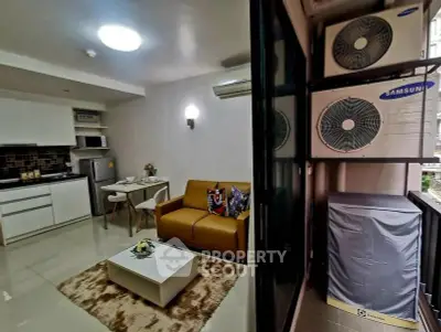 Modern living room with kitchenette and balcony air conditioning units.
