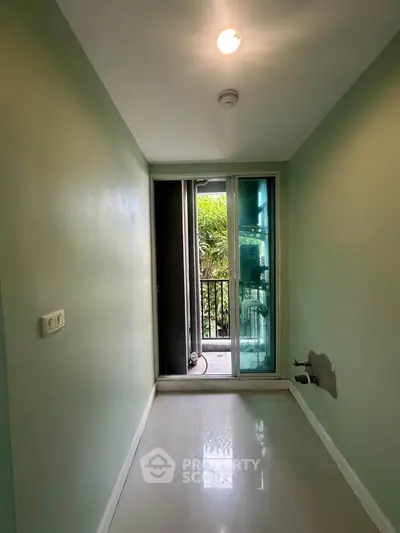 Compact balcony area with sliding glass doors and green walls