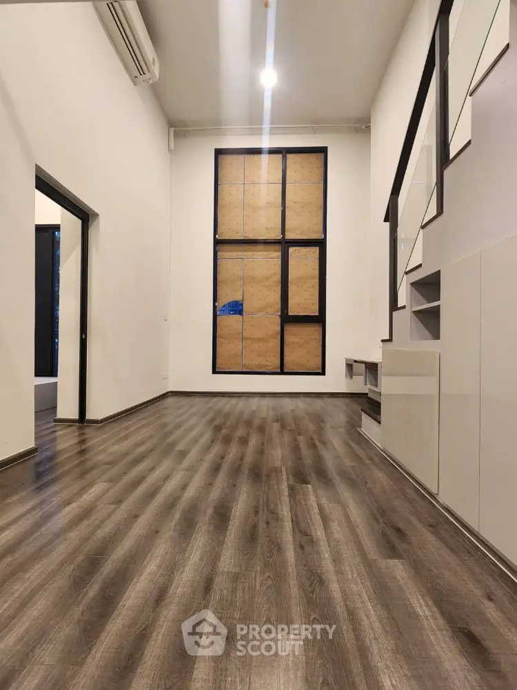 Spacious modern living room with wooden flooring and staircase