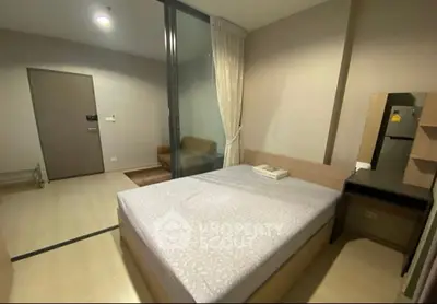 Modern bedroom with cozy bed and sliding glass partition in stylish apartment