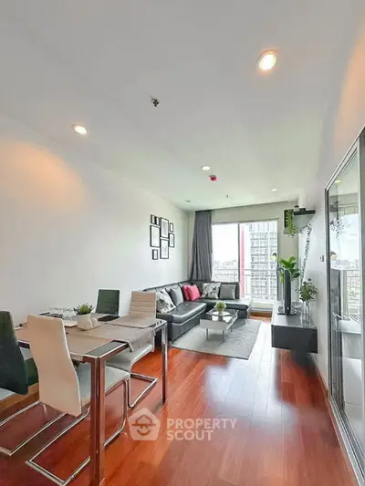 Modern living room with city view, stylish decor, and hardwood floors in a high-rise apartment.
