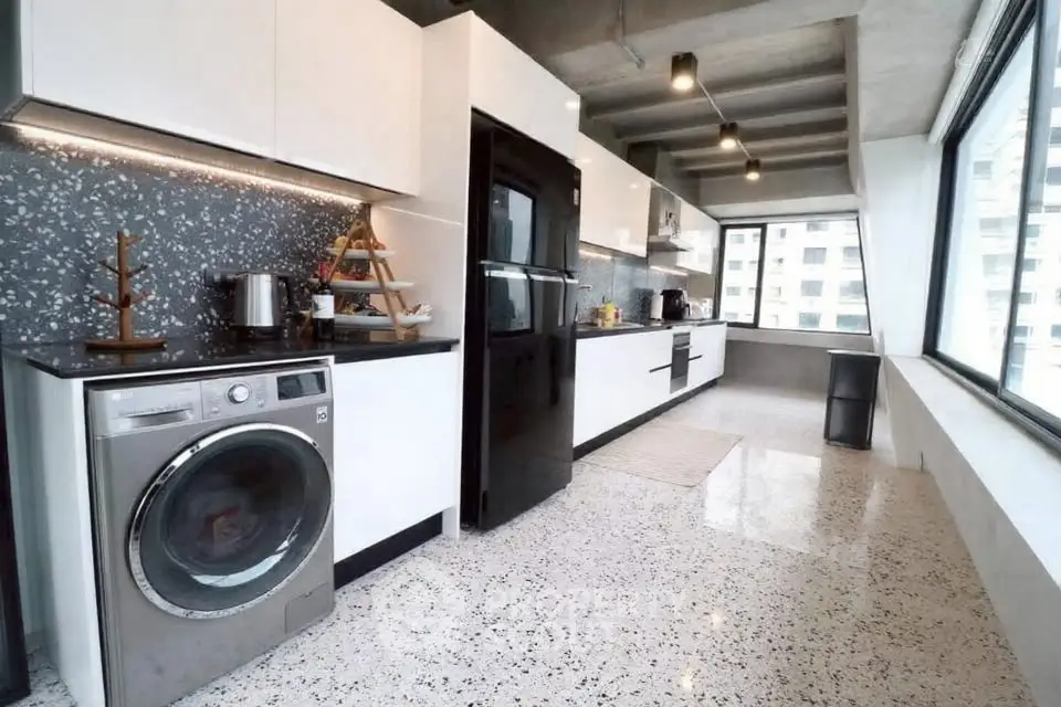 Modern kitchen with sleek appliances and large windows offering city views.