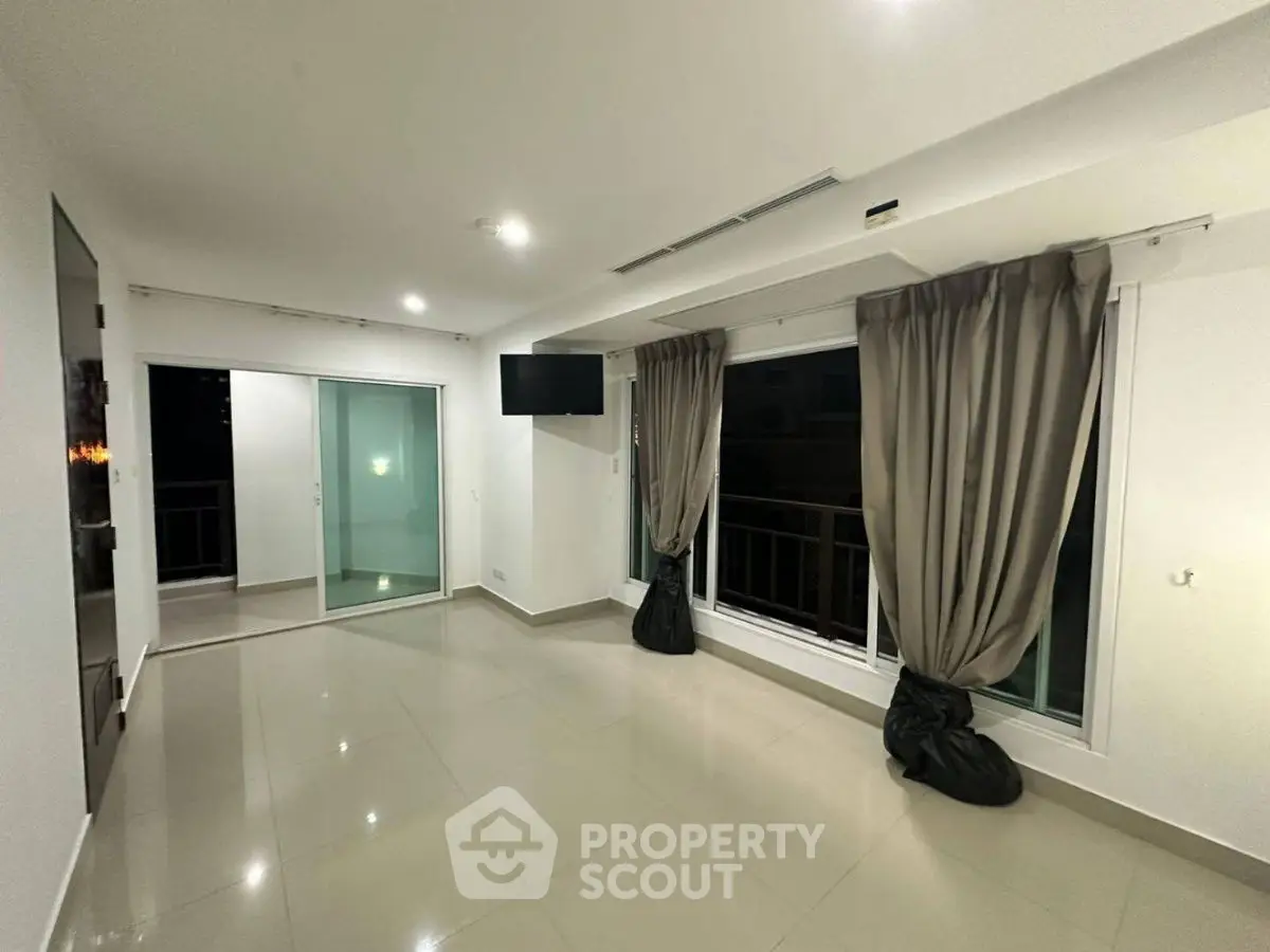 Spacious modern living room with large windows and elegant curtains